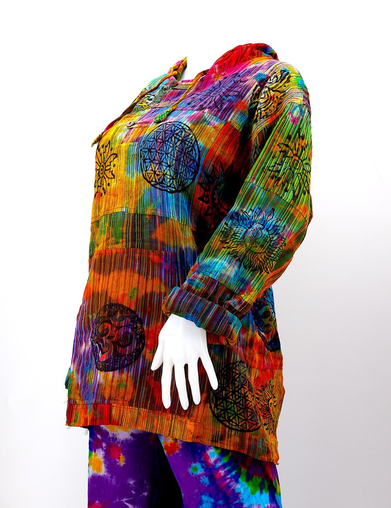 K&ouml;nnte beinhalten: Ein farbenfrohes, tie-dye-Shirt mit langen &Auml;rmeln und Knopfleiste. Das Shirt zeigt verschiedene Muster, darunter Sonnen, Blumen und geometrische Designs. Das Shirt ist aus einem weichen, leichten Stoff gefertigt und perfekt zum Schichten.