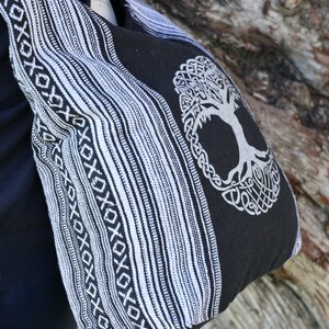 May include: Black and white striped tote bag with a tree of life design. The bag has a woven pattern and a large tree of life design in the centre.