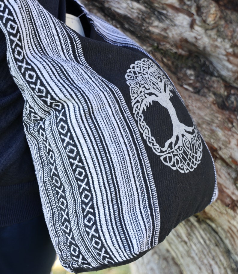May include: Black and white striped tote bag with a tree of life design. The bag has a woven pattern and a large tree of life design in the centre.
