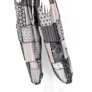 May include: Black and white patchwork pants with a geometric pattern. The pants have a drawstring waist and a loose fit.