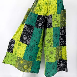 Puede incluir: Pantalones patchwork de pernera ancha en tonos verdes, negros y amarillos. La tela presenta dise&ntilde;os celestiales y de manos. Los pantalones tienen cintura el&aacute;stica y bolsillos.