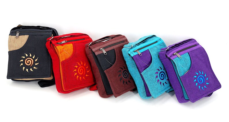 May include: Six different colored canvas crossbody bags with a sun design. The bags are all the same size and shape, and they have a zipper closure. The bags are made of a durable canvas material and are perfect for everyday use.
