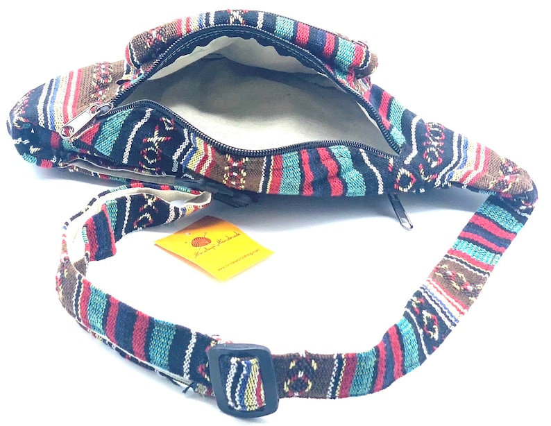 K&ouml;nnte beinhalten: Eine bunte, gestreifte Stoff-Bauchtasche mit Rei&szlig;verschluss und verstellbarem Gurt. Der Gurt ist aus dem gleichen Stoff wie die Tasche. Die Tasche ist offen und das Innere ist mit einem beigefarbenen Stoff ausgekleidet.