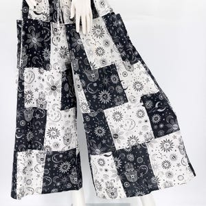 Puede incluir: Pantalones de pierna ancha con un dise&ntilde;o de patchwork con s&iacute;mbolos celestiales y dibujados a mano en blanco y negro. Los pantalones tienen una cintura el&aacute;stica con cord&oacute;n y bolsillos. La tela es ligera y fluida, adecuada para ropa casual.