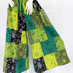 Puede incluir: Pantalones anchos de patchwork en tonos verdes, negros y amarillos. Los pantalones presentan un patr&oacute;n repetido de s&iacute;mbolos celestiales y de manos. La cintura es el&aacute;stica. Los pantalones se exhiben en un maniqu&iacute;.