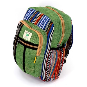 Könnte beinhalten: Grüner Hanfrucksack mit einem bunten gewebten Muster an der Seite. Der Rucksack hat eine Reißverschlusstasche auf der Vorderseite und ein Etikett mit der Aufschrift "HIMALAYA Hemp Textiles Made in Nepal".