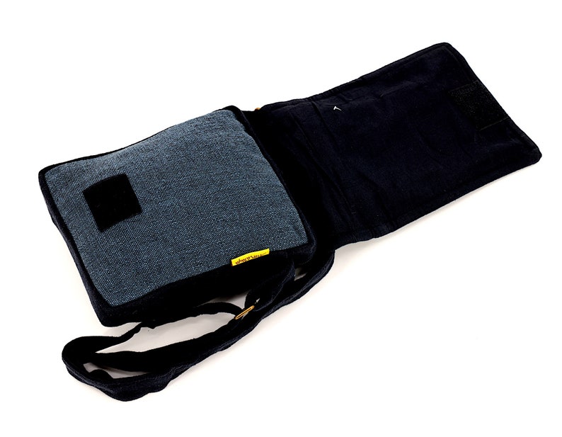 May include: A black and blue canvas messenger bag with a flap closure and an adjustable shoulder strap. The bag has a small pocket on the front and a larger pocket on the inside.