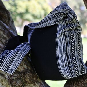 May include: Black and white striped tote bag with a woven design. The bag is made from a soft, durable fabric and has a spacious interior.