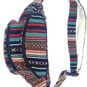 K&ouml;nnte beinhalten: Eine schwarze, rote, braune, gr&uuml;ne und gelbe gestreifte Bauchtasche mit Rei&szlig;verschluss und verstellbarem Gurt.