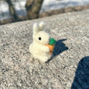 Lapin blanc en laine feutrée à l'aiguille avec carotte