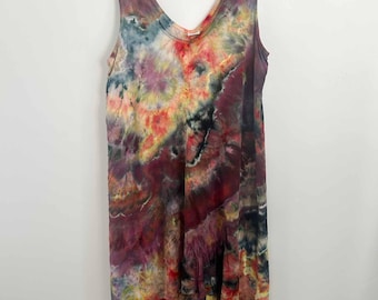 May include: A sleeveless dress featuring a multi-colored tie-dye pattern with deep shades of burgundy, purple, orange, yellow, and hints of blue. The garment has a V-neckline and an asymmetrical hemline that is longer in the back than the front.