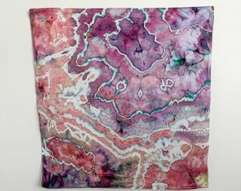May include: A square fabric piece featuring a tie-dye pattern with shades of magenta, deep purple, soft pink, and teal. The design displays organic, swirling lines and geode-like shapes with white negative space creating a marbled effect.