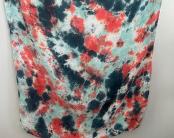 May include: A square scarf featuring a tie-dye pattern with blended colors of dark charcoal, bright coral red, and pale mint green. The fabric displays a soft, mottled texture with irregular shapes and overlapping color transitions throughout.