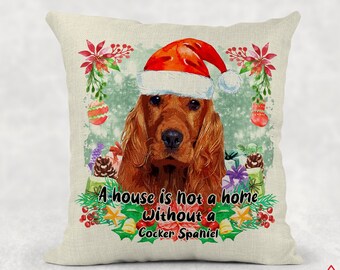 May include: A white throw pillow with a Christmas-themed design featuring a red and white Santa hat on a brown Cocker Spaniel dog. The text on the pillow reads "A house is not a home without a Cocker Spaniel."