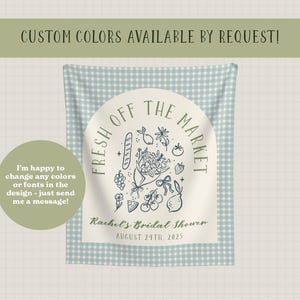 May include: A light blue and white gingham patterned fabric backdrop with a circular design that reads "Fresh Off The Market". The design includes illustrations of a baguette, flowers, and fruit. Text at the bottom reads "Rachel's Bridal Shower August 24th, 2025".