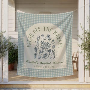 May include: A light blue and white gingham fabric banner with the text "FRESH OFF THE MARKET" in a circular design. Below the text is "Rachel's Bridal Shower" and the date "AUGUST 24TH, 2025". The banner has illustrations of fruits and flowers.