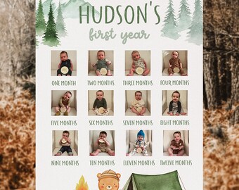Peut inclure: Un panneau blanc avec un fond aquarelle de montagnes et d'arbres verts. Le texte "HUDSON'S first year" est en haut du panneau. Il y a 12 photos d'un bébé garçon, une pour chaque mois de l'année. Les photos sont disposées en grille de quatre rangées et trois colonnes. Le bas du panneau présente une illustration de dessin animé d'un ours portant un sac à dos, un feu de camp et une tente verte.
