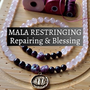May include: A mala necklace with rose quartz beads, dark purple beads, and a gold lotus pendant. The image includes the text "MALA RESTRINGING Repairing & Blessing" and spools of pink thread.