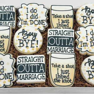 May include: A box of decorated cookies with various phrases. Some cookies say "Straight Outta Marriage," "I do, I did, I'm done," and "Boy Bye!" The cookies have a white base with black and yellow accents.