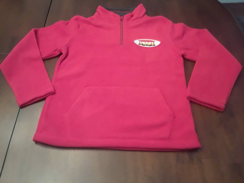 Red fleece Sweater with a Trolley Patch.