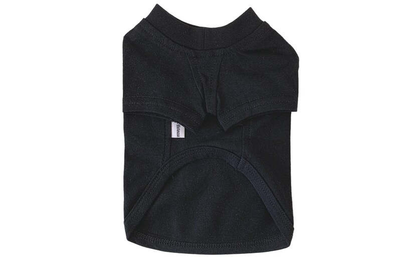 Puede incluir: Una camiseta negra para perro con una peque&ntilde;a etiqueta blanca que dice "Basic".