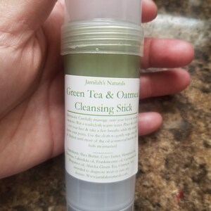 May include: A green and white cleansing stick with the text "Jamilah's Naturals Green Tea & Oatmeal Cleansing Stick" on the label. The ingredients are listed on the label: Shea Butter, Cocoa Butter, Hempseed Oil, Calendula Oil, Frankincense Oil, Coconut Oil, Matcha Green Tea, Oatmeal. Not intended to diagnose, treat or cure any disease. www.jamilahsnaturals.com