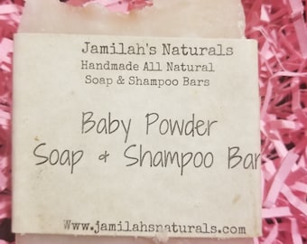 May include: A white bar of soap with the text "Jamilah's Naturals Handmade All Natural Soap & Shampoo Bars Baby Powder Soap & Shampoo Bar Www.jamilahsnaturals.com" printed on the label.