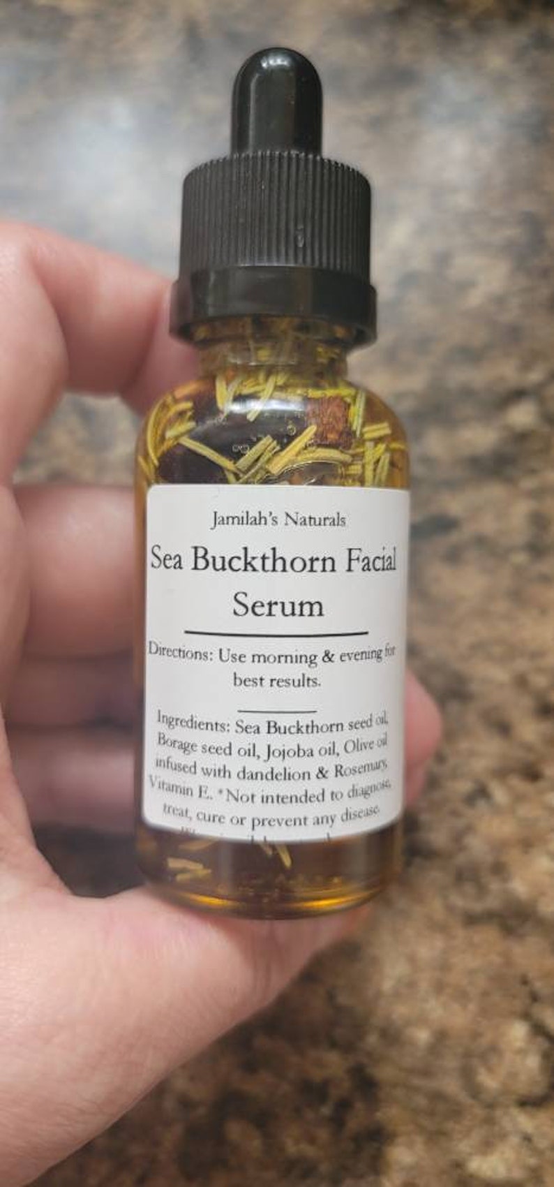 May include: A glass bottle with a dropper top filled with a yellow liquid. The label reads "Jamilah's Naturals Sea Buckthorn Facial Serum". The label also includes directions for use and a list of ingredients.