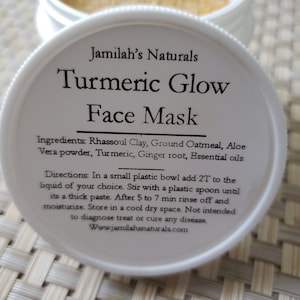 May include: A white jar with a yellow powder inside. The label reads "Jamilah's Naturals Turmeric Glow Face Mask". The ingredients are listed as Rhassoul Clay, Ground Oatmeal, Aloe Vera powder, Turmeric, Ginger root, and Essential oils. Directions for use are also included.
