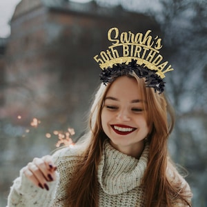 Puede incluir: Una mujer con un su&eacute;ter blanco con texto en brillo negro y dorado que dice "Sarah's 50th Birthday" en una diadema.