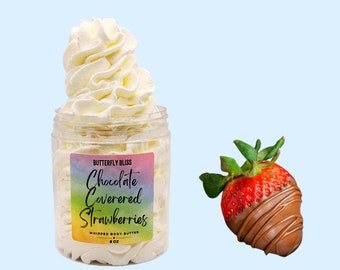 May include: A jar of whipped body butter with a rainbow label that reads "Butterfly Bliss Chocolate Covered Strawberries Whipped Body Butter 8 oz". The jar is filled with white whipped body butter and a dollop of whipped body butter is on top of the jar. A chocolate-covered strawberry is in the background.