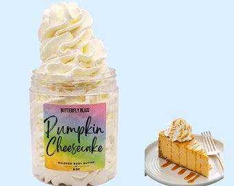May include: A jar of whipped body butter with a white swirl on top. The jar has a label that says "Butterfly Bliss Pumpkin Cheesecake Whipped Body Butter 8 oz". A slice of pumpkin cheesecake with caramel sauce is shown in the background.