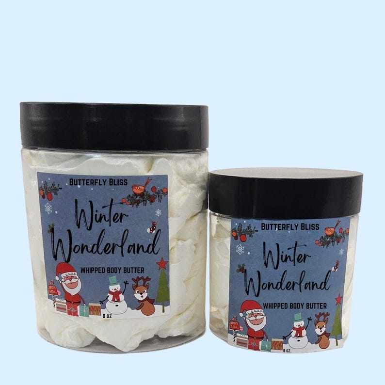 May include: Two jars of white whipped body butter with a winter wonderland theme. The jars are labeled "Butterfly Bliss Winter Wonderland Whipped Body Butter" and feature a snowman, Santa Claus, and a reindeer. The smaller jar is 8 oz and the larger jar is 8 oz.