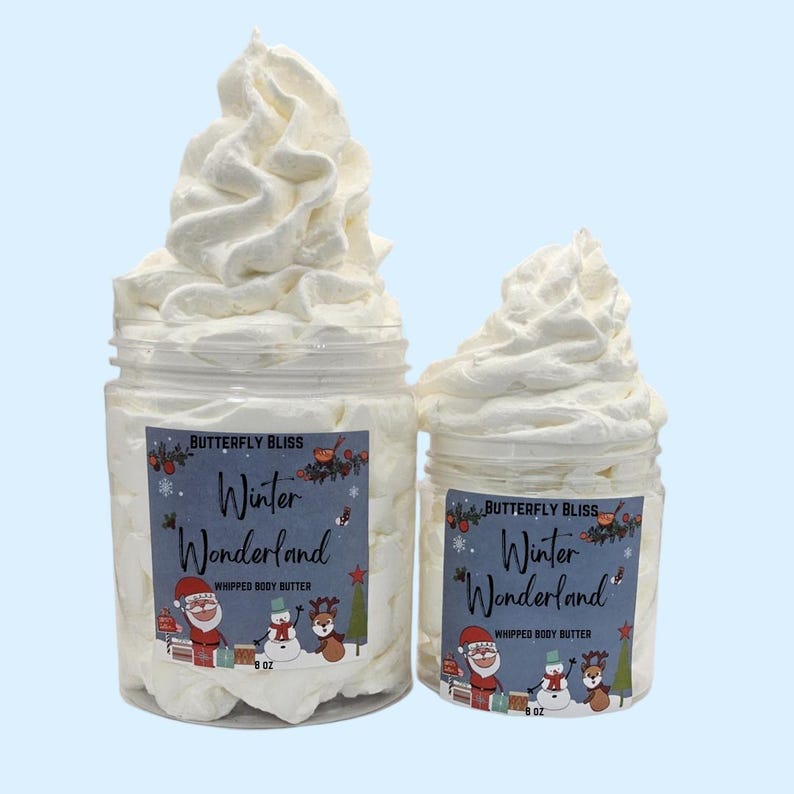 May include: Two jars of whipped body butter, both labeled "Butterfly Bliss Winter Wonderland Whipped Body Butter". The jars are filled with white whipped cream and have a festive winter design on the labels.