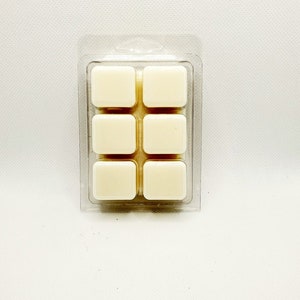 May include: A clear plastic package containing six white wax melts, arranged in a 2x3 grid.