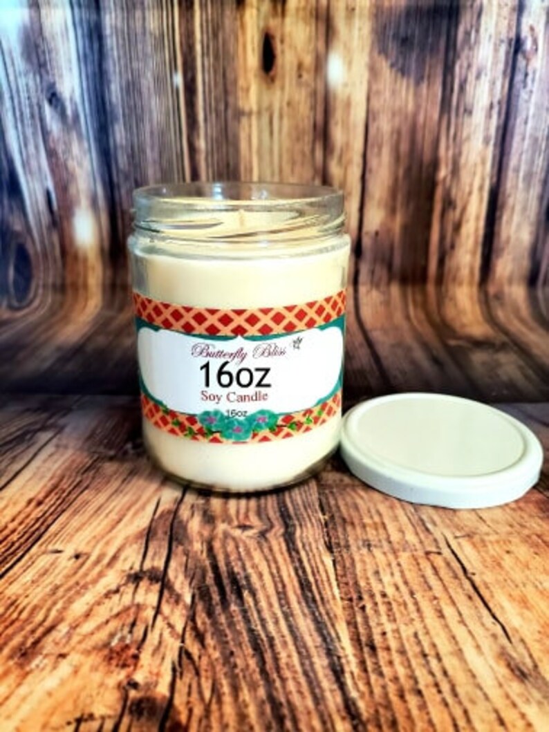 May include: A 16 oz soy candle in a clear glass jar with a red, white, and blue patterned label that says "Butterfly Bliss".