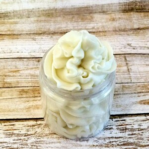 K&ouml;nnte beinhalten: Ein klares Glasgef&auml;&szlig; gef&uuml;llt mit wei&szlig;er, geschlagenem K&ouml;rperbutter. Die Butter ist verwirbelt und hoch im Gef&auml;&szlig; gestapelt.