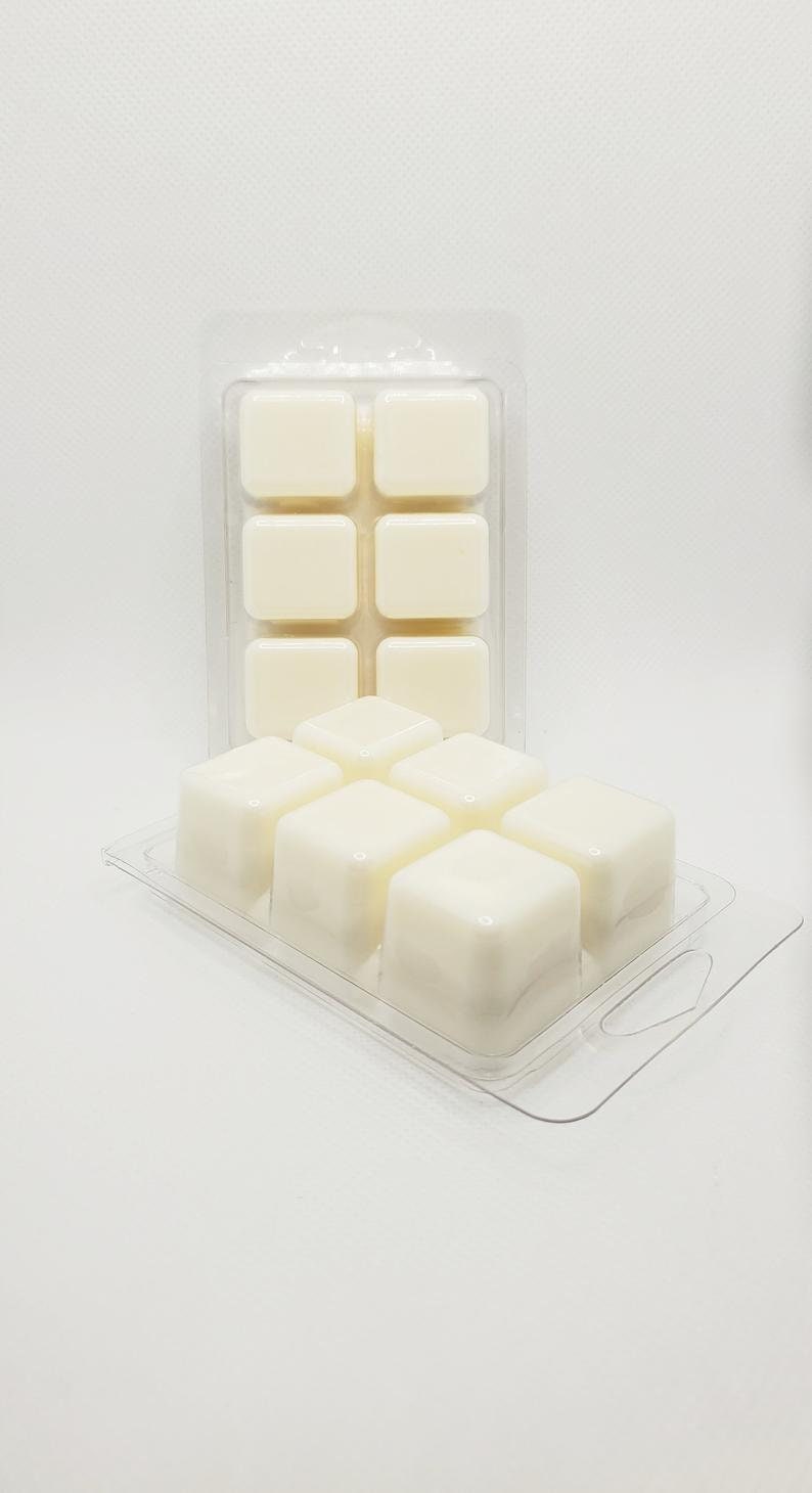 May include: A clear plastic tray with nine white wax melts. The wax melts are in a grid pattern and are ready to be used in a wax warmer.