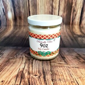 K&ouml;nnte beinhalten: Eine 9 Unzen Sojawachskerze in einem klaren Glasgef&auml;&szlig; mit wei&szlig;em Deckel. Das Etikett ist rot, wei&szlig; und blau mit dem Text "Butterfly Bliss" und "Soy Candle".