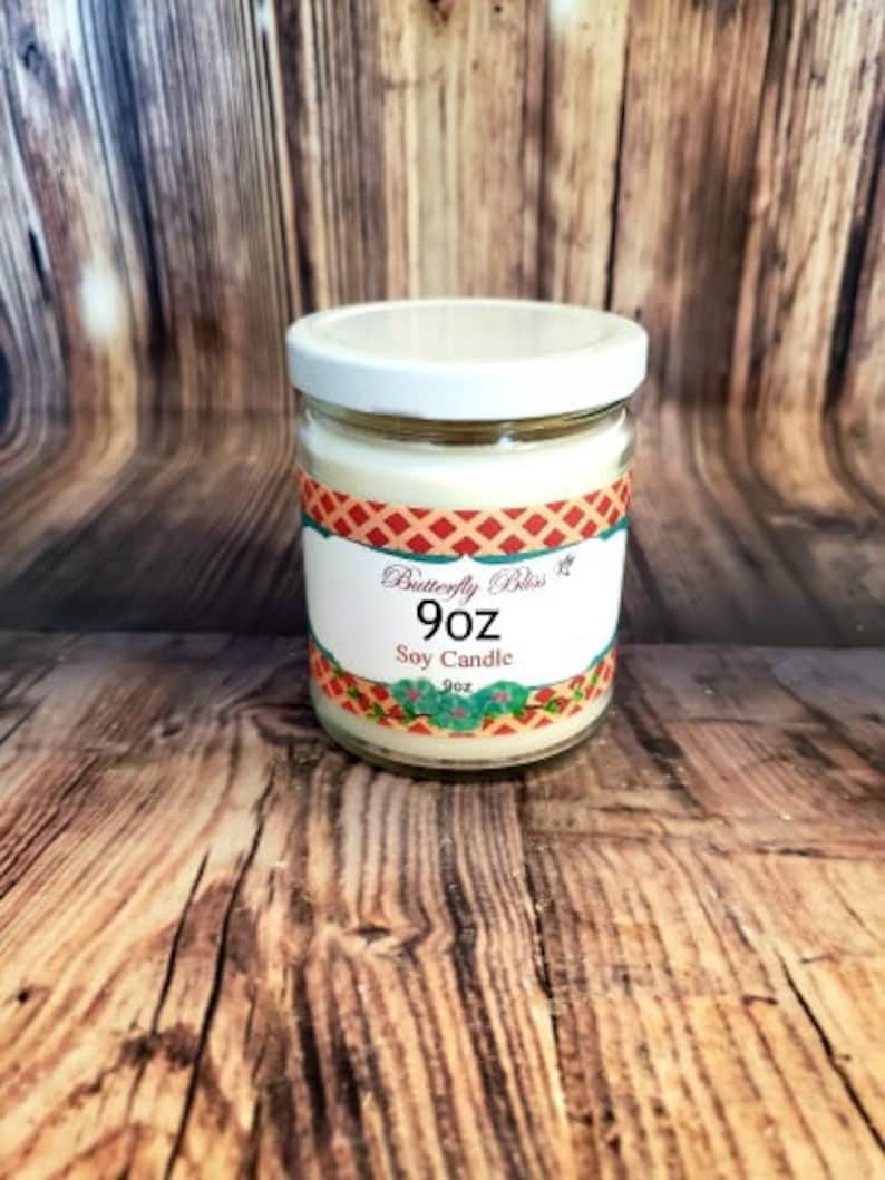 K&ouml;nnte beinhalten: Eine 9 Unzen Sojawachskerze in einem klaren Glasgef&auml;&szlig; mit wei&szlig;em Deckel. Das Etikett ist rot, wei&szlig; und blau mit dem Text "Butterfly Bliss" und "Soy Candle".