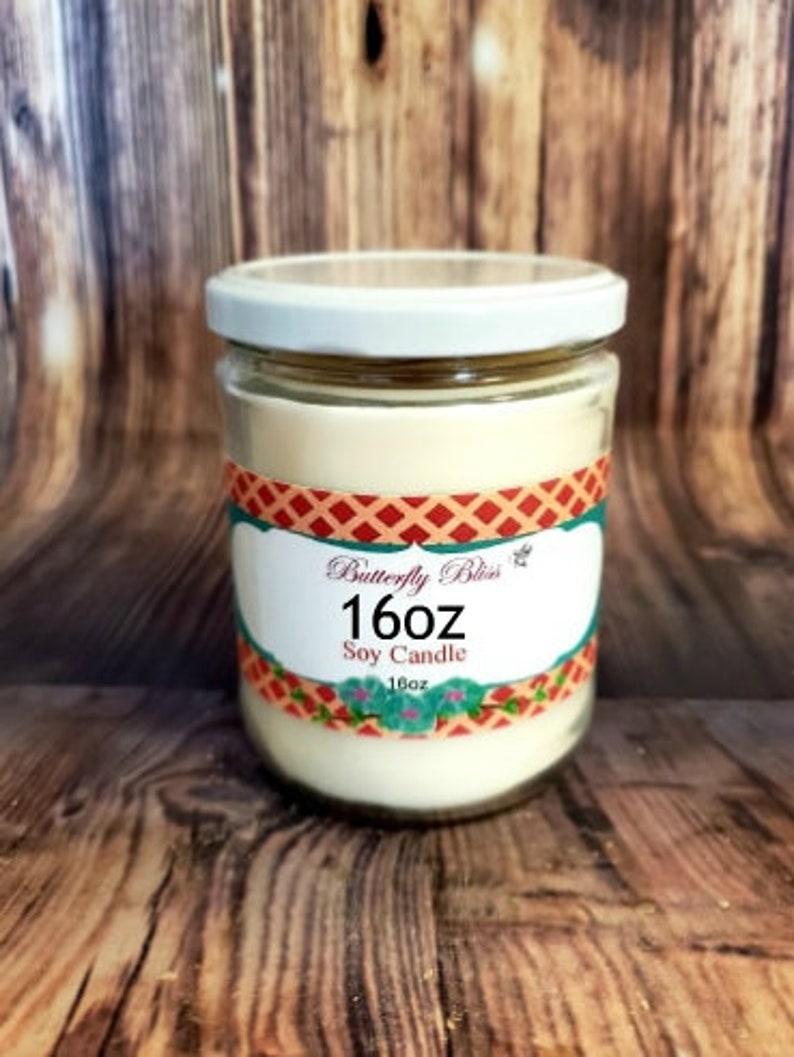 May include: A 16 ounce soy candle in a clear glass jar with a white lid. The label is red, white, and blue with the text "Butterfly Bliss" and "16oz Soy Candle".