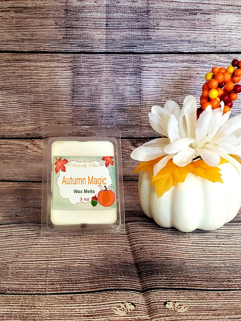 May include: A 3 ounce wax melt in a clear plastic container with a label that says "Butterfly Bliss" and "Autumn Magic" with a small pumpkin graphic.