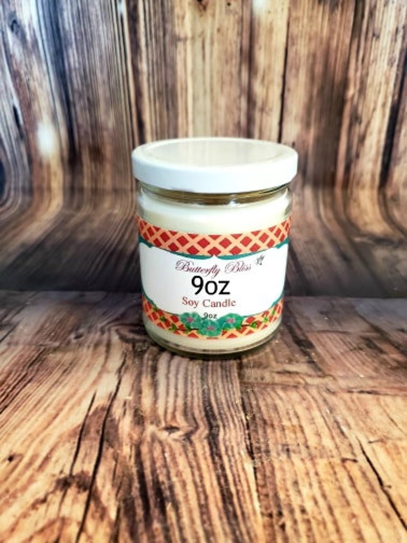 May include: A 9 ounce soy candle in a clear glass jar with a white lid. The label is red, white, and blue with the text "Butterfly Bliss" and "Soy Candle".