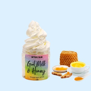 May include: A jar of whipped body butter with a rainbow label that reads "Butterfly Bliss Goat Milk & Honey Whipped Body Butter 4 oz". The jar is filled with white whipped cream. There is a honeycomb, turmeric root, and turmeric powder in the background.