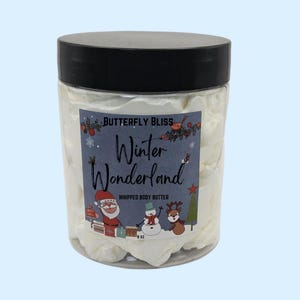 May include: A white whipped body butter in a clear jar with a black lid. The jar has a label that says "Butterfly Bliss Winter Wonderland Whipped Body Butter 8 oz.". The label features a cartoon Santa Claus, snowman, and reindeer.
