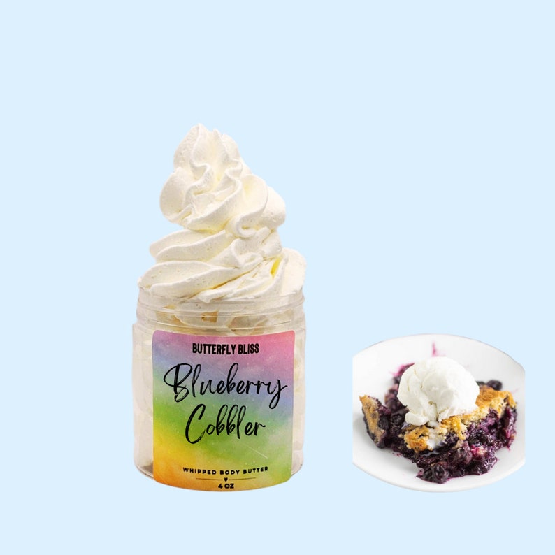 May include: A 4 oz jar of whipped body butter with a rainbow label that reads "Butterfly Bliss Blueberry Cobbler Whipped Body Butter". The jar is filled with a white whipped cream and a blueberry cobbler is shown in the background.