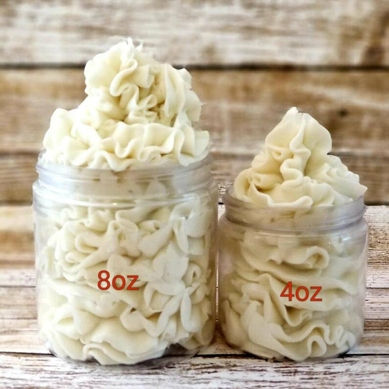 K&ouml;nnte beinhalten: Zwei durchsichtige Gl&auml;ser mit wei&szlig;er K&ouml;rperbutter, eines mit der Aufschrift "8oz" und das andere mit "4oz".
