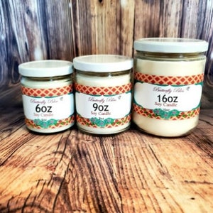 K&ouml;nnte beinhalten: Drei Sojawachskerzen in Glasbeh&auml;ltern mit Etiketten. Die Kerzen haben die Gr&ouml;&szlig;en 6 oz, 9 oz und 16 oz. Die Etiketten sind orange, gr&uuml;n und wei&szlig; mit dem Text "Butterfly Bliss" und "Soy Candle".