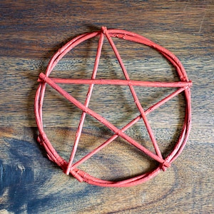 Può includere: Un ornamento a pentagramma circolare costruito con sottili ramoscelli dipinti di rosso. Il design presenta una stella a cinque punte racchiusa in una cornice circolare, con tutti i componenti fissati saldamente nei punti di intersezione.