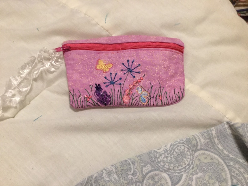 Pink in colored embroidered flowers with small Butterflies on it. 5.5 x 4.5 in size Embroidered bag